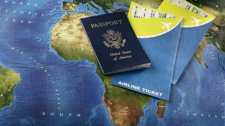 Passaporte americano e tickets de voo sobre mapa mundial
