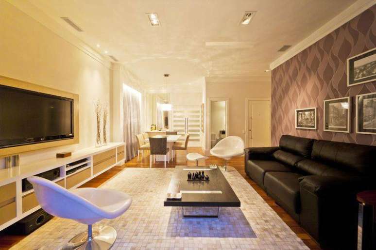 22. Observe como colocar papel de parede de apenas um lado do ambiente pode destacar o espa&ccedil;o. Projeto de Enzo Sobocinski