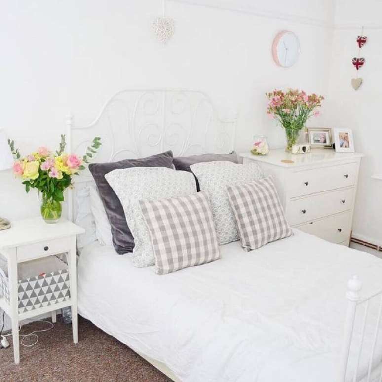 48. Aqui as cores para quarto feminino todo branco ficou por conta das flores ao lado da cama dando um ar mais romântico ao ambiente – Foto: Amy Sowerby