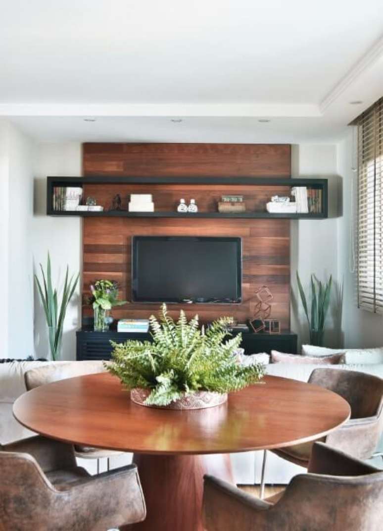 32. Sala integrada com mesa redonda e painel de TV de madeira. Projeto de Tetriz Arquitetura