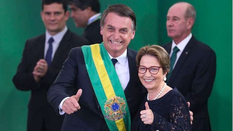 Tereza Cristina posa para foto com Bolsonaro na posse presidencial. Ao fundo (esq.), Sergio Moro observa