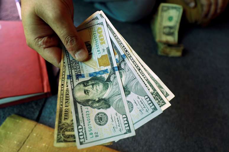 Trader mostra notas de 100 dólares em corretora de câmbio. 3/12/2018. REUTERS/Fayaz Aziz.