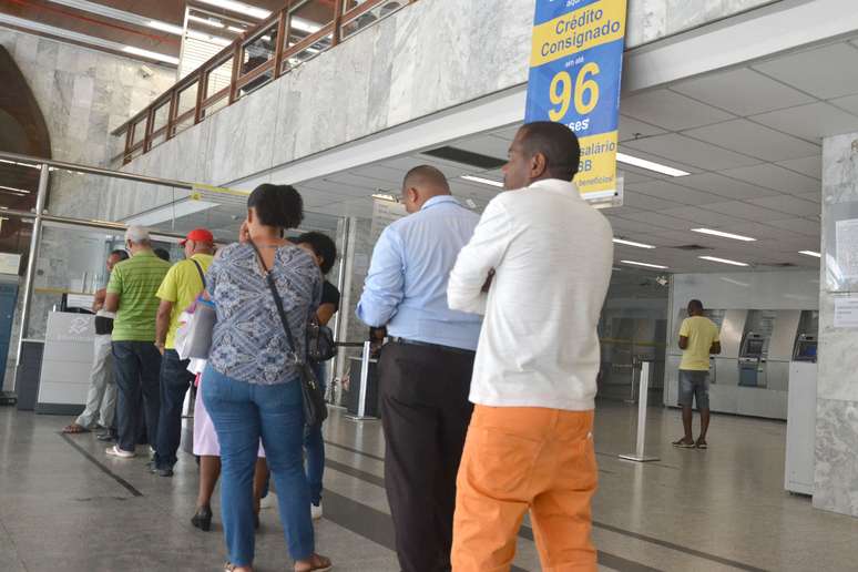 Pessoas perfiladas aguardando atendimento