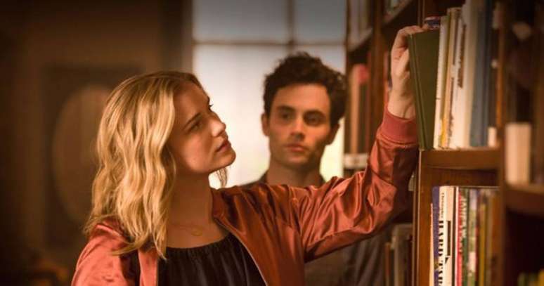 O gerente de livraria Joe Goldberg observa a cliente Guinevere Beck, jovem aspirante a escritora, na s&eacute;rie 'You', da Netflix.