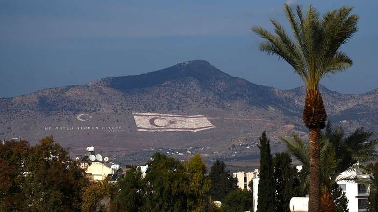 Bandeira da República Turca de Chipre do Norte pintada em uma montanha na cidade de Nicósia, capital do país - dividida ao meio pela Linha Verde