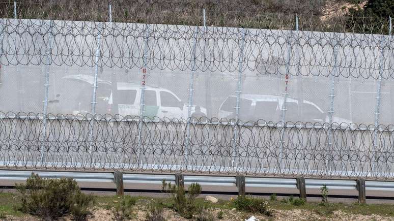 Agentes americanos perto de uma cerca dividindo a fronteira entre EUA e México em foto de dezembro de 2018