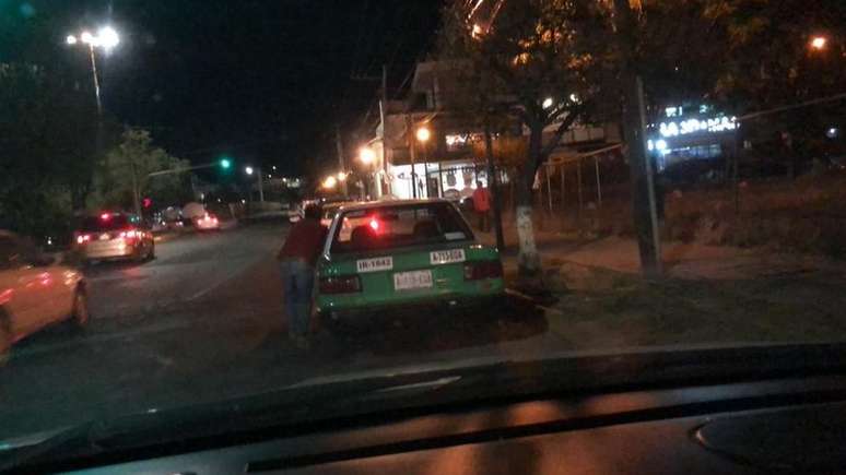 Um motorista de táxi empurra seu carro em Guanajuato, no México