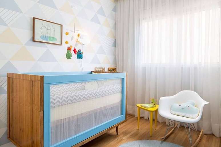 22. Decoração em tons pastéis para quarto de bebê moderno com berço de madeira pintado de azul e cadeira de balanço branca – Foto: Studio Novak