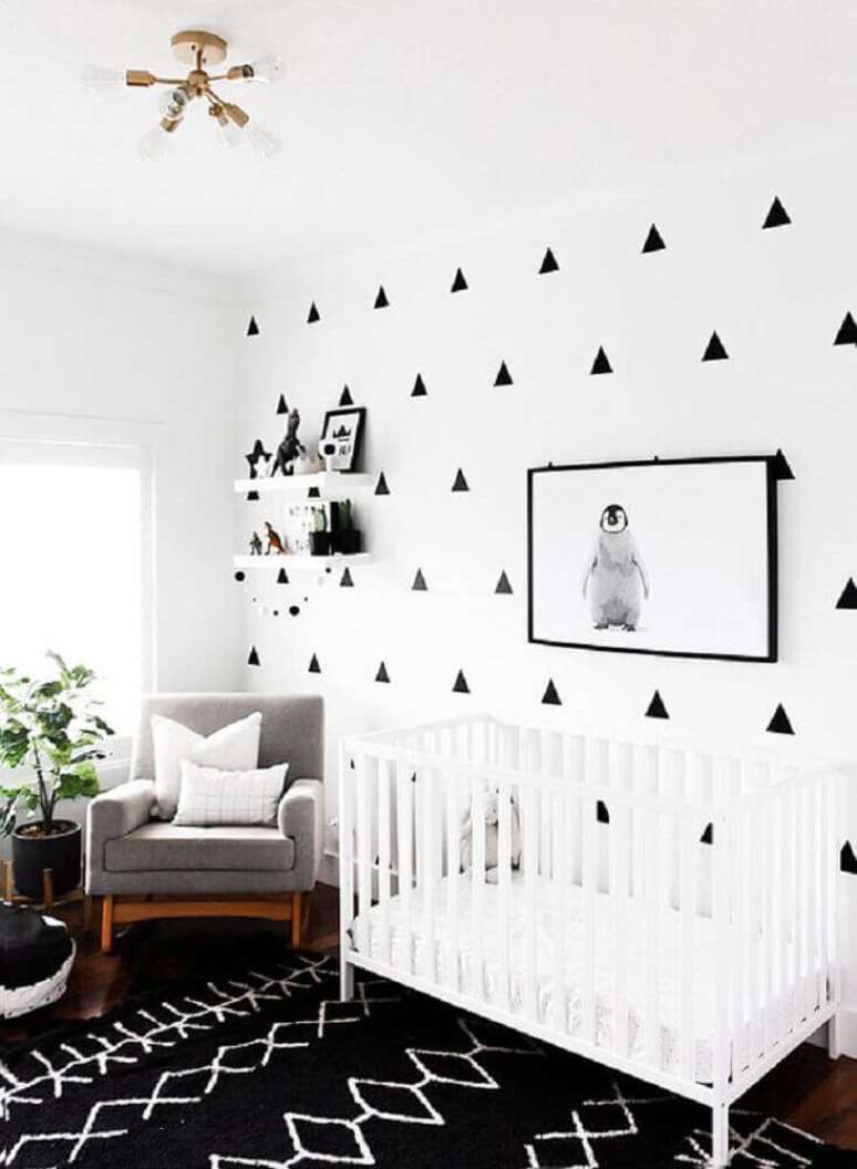36. Decoração para quarto de bebê moderno com tapete preto, parede com adesivos de triângulos e quadro com foto de bebê pinguim – Foto: Paper Llamas