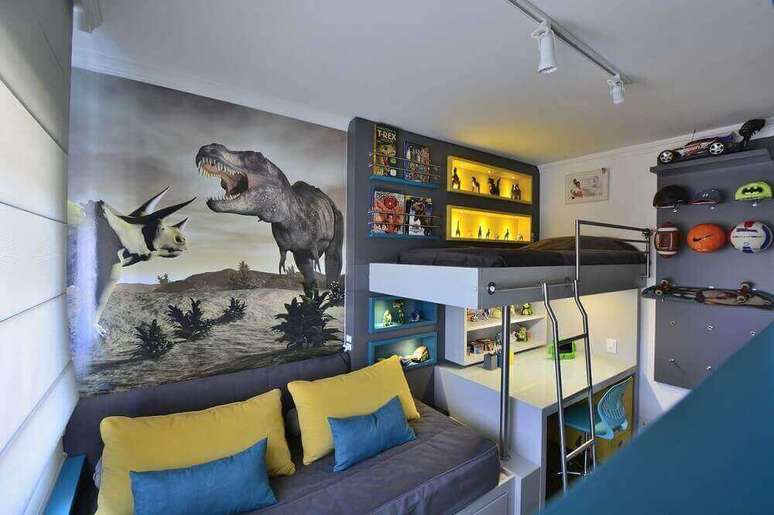 10. Decoração para quarto de solteiro moderno em tons de cinza, amarelo e azul com adesivo de dinossauro na parede – Foto: BG Arquitetura