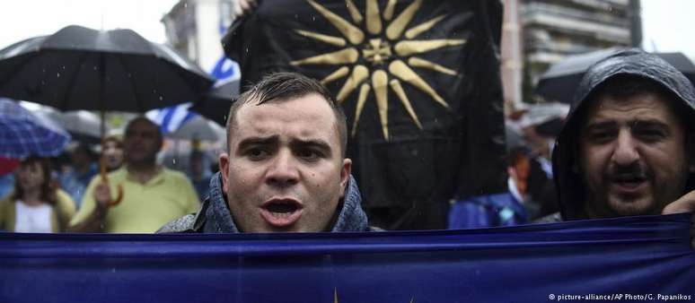 Manifestantes gregos erguem faixa com o Sol de Vergina, símbolo encontrado na tumba de reis da Macedônia Antiga 
