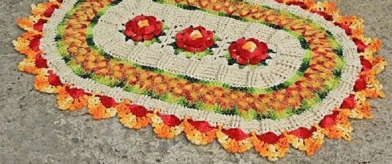 51. Tapete crochê oval com flor vermelha e detalhes em amarelo e laranja – Foto: Artes da Desi