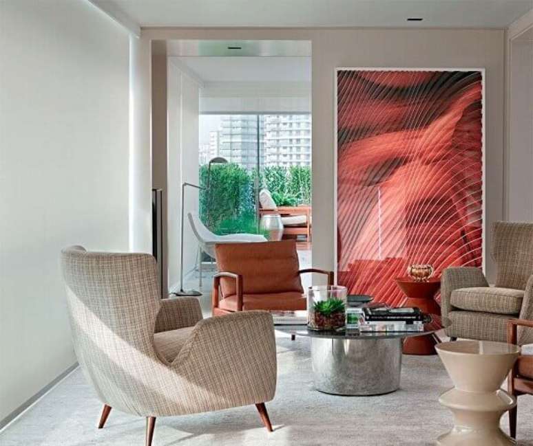 39- Na sala, o tom palha dos objetos de decora&ccedil;&atilde;o, estofados e paredes contrastam com o quadro vermelho. Fonte: Pinterest