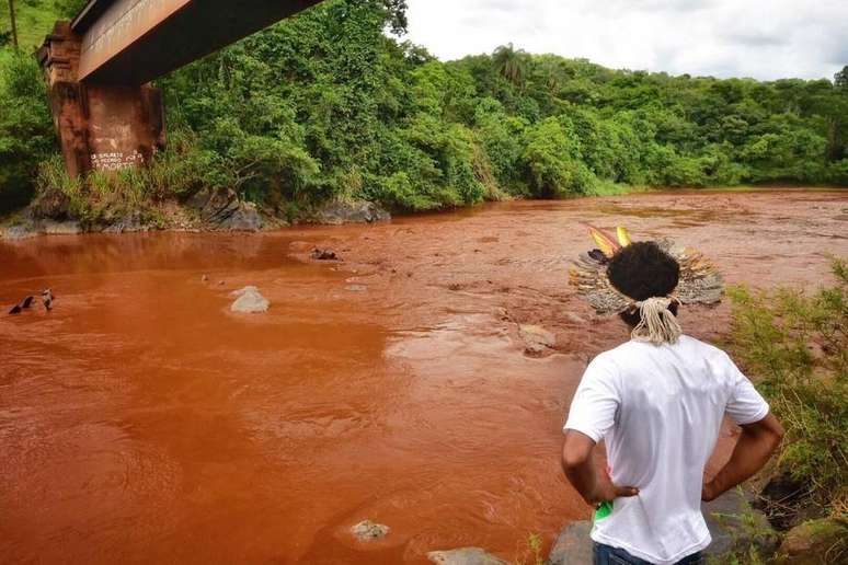 Indígena observa o rio Paraopeba tomado pela lama