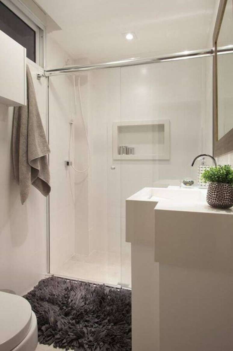 27. Decoração de banheiro pequeno com tapete felpudo cinza – Foto: Sartori Design