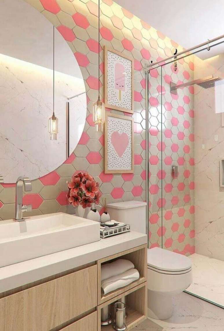 68. Decoração com gabinete para banheiro pequeno decorado com luminária pendente, espelho redondo e azulejo cor de rosa e bege – Foto: Wood Save