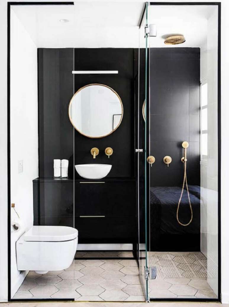 73. Modelo de banheiro pequeno e moderno decorado em preto e branco com chuveiro e torneiras douradas – Foto: Yaggpro