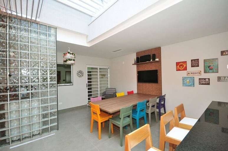 24. Decora&ccedil;&atilde;o para cozinha ampla com cadeiras coloridas e cobog&oacute; de vidro &ndash; Foto: Condecorar