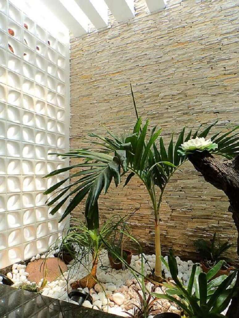 42. Decoração para jardim de inverno com revestimento de pedra canjiquinha e parede de cobogó cerâmico branco – Foto: Webcomunica