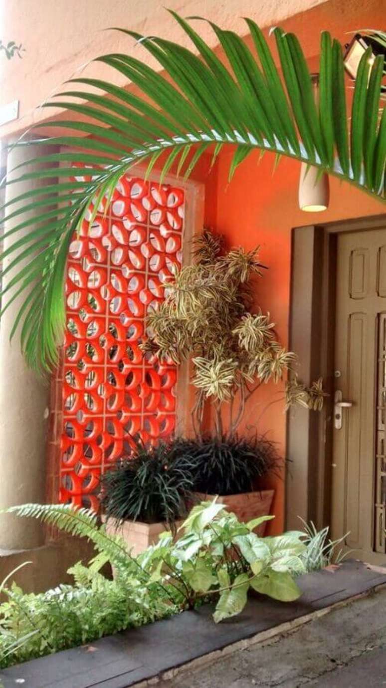 52. Decoração de varanda com cobogó pintado de vermelho e várias plantas – Foto: Pinterest