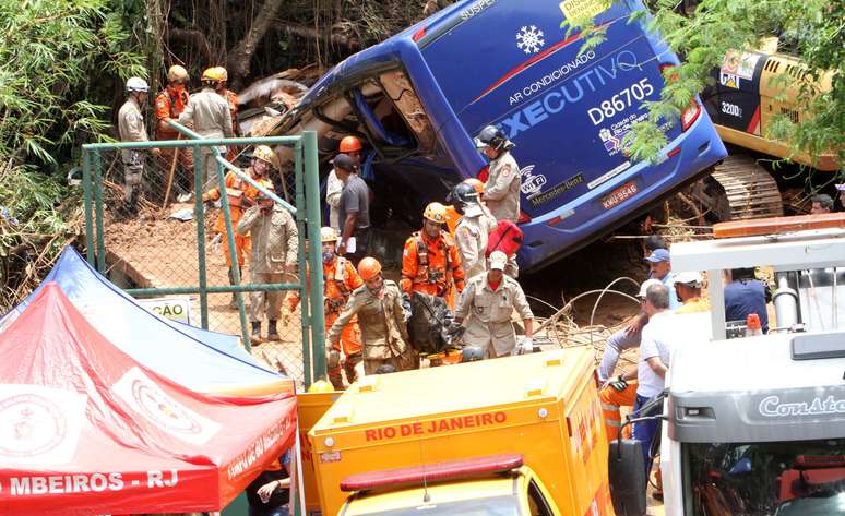 Bombeiros retiram um corpo do ônibus que foi soterrado na Avenida Niemeyer após deslizamento na Favela do Vidigal, na Zona Sul do Rio, durante forte chuva na noite de quarta-feira (07/02/2019)