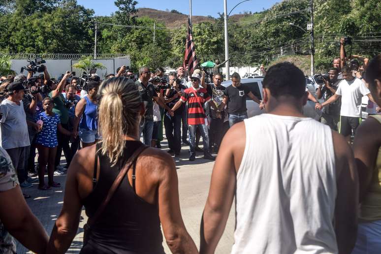 Familiares e amigos das vítimas fazem uma oração em frente ao Centro de Treinamento do Flamengo, em Vargem Grande, zona oeste do Rio de Janeiro, onde um incêndio deixou dez mortos na madrugada desta sexta-feira (08/02/2019)