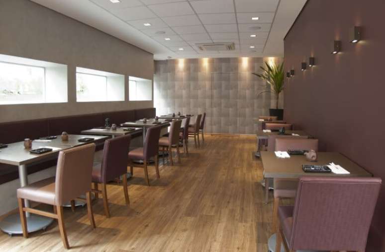 49. Salão de restaurante com piso vinílico em contraste com decoração marrom e roxa. Projeto de Monica Spada Durante
