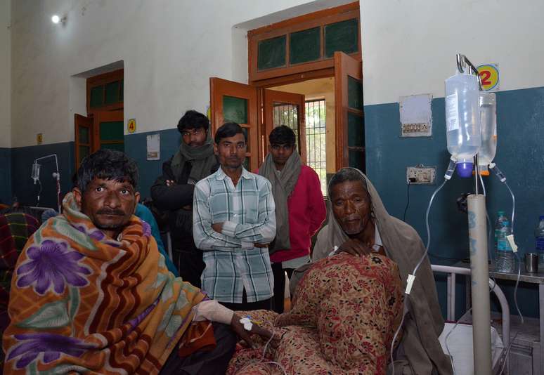 Homens são atendidos após consumirem bebida falsificada em Saharanpur, no norte da Índia