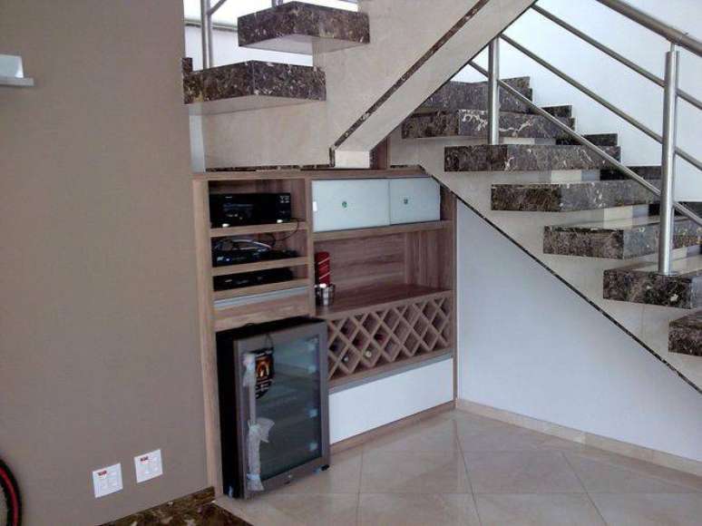 27. O espaço abaixo da escada pode abrigar um bar com uma adega climatizada