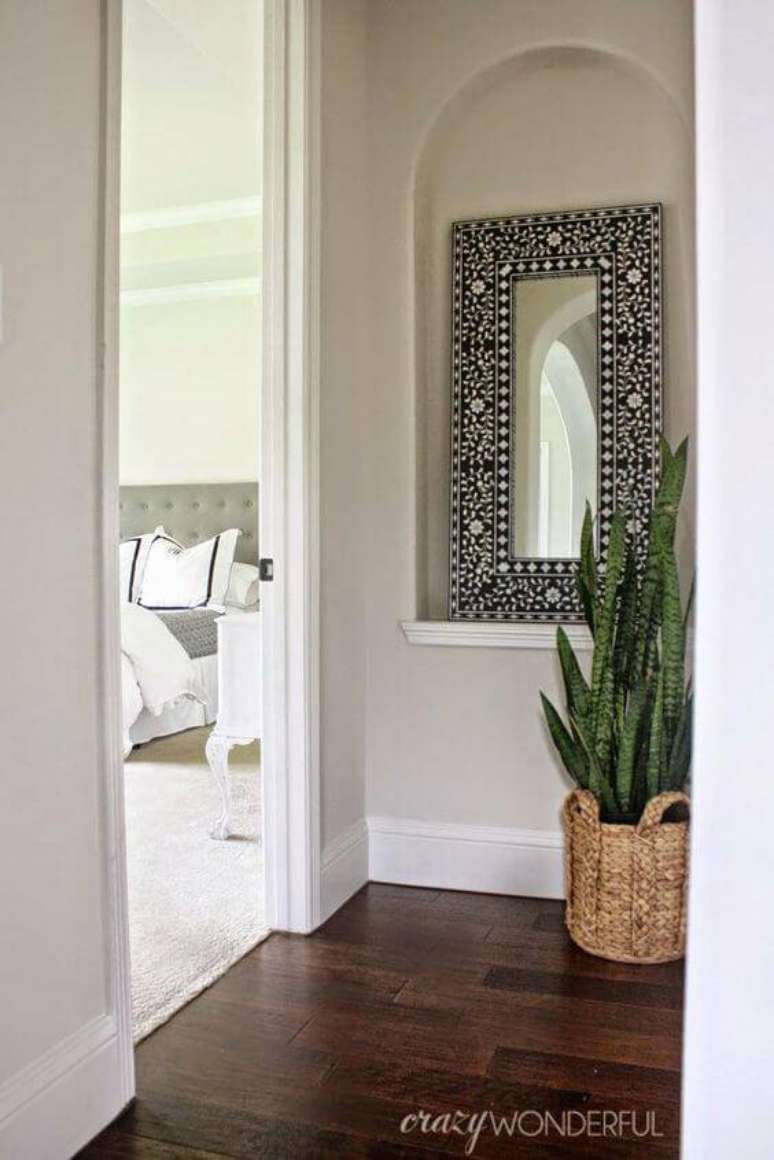 11. Aposte em um vaso de plantas r&uacute;stico no corredor&nbsp;para deix&aacute;-lo mais bonito e combine com um espelho detalhado para dar mais estilo