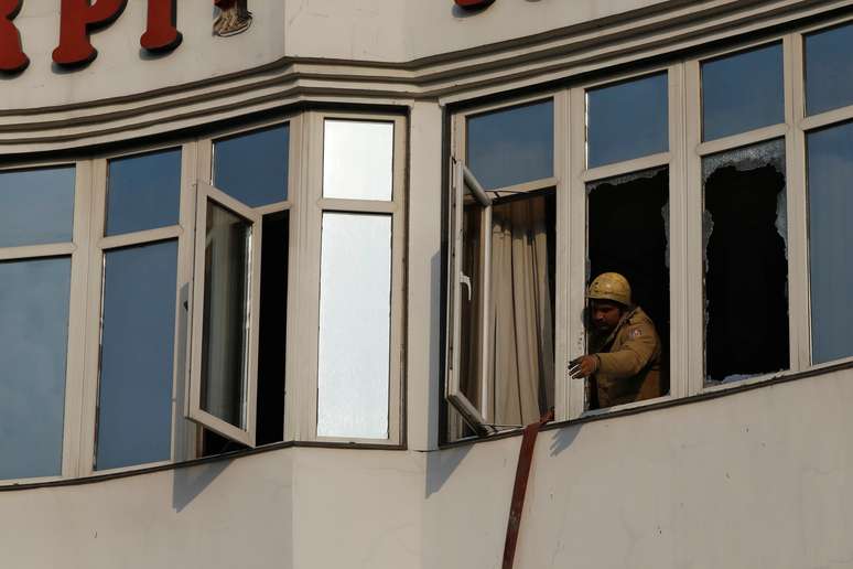 Bombeiro trabalha em janela de hotel que pegou fogo em Nova Délhi
