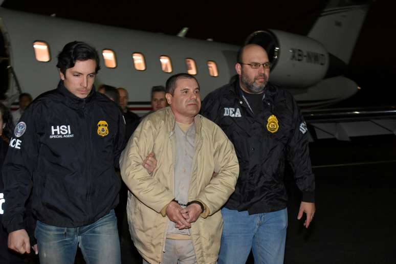 Joaquin "El Chapo" Guzman é escoltado por policiais no aeroporto após ter sido extraditado do México para os Estados Unidos. 19/1/2017.  U.S. officials/Handout 
