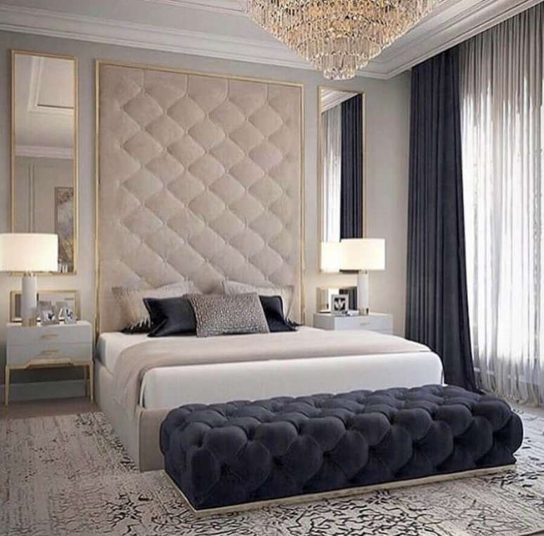 35. Decora&ccedil;&atilde;o sofisticada com lustre de cristal para quarto de casal com recamier capiton&ecirc; azul marinho e parede estofada &ndash; Foto: Zozu