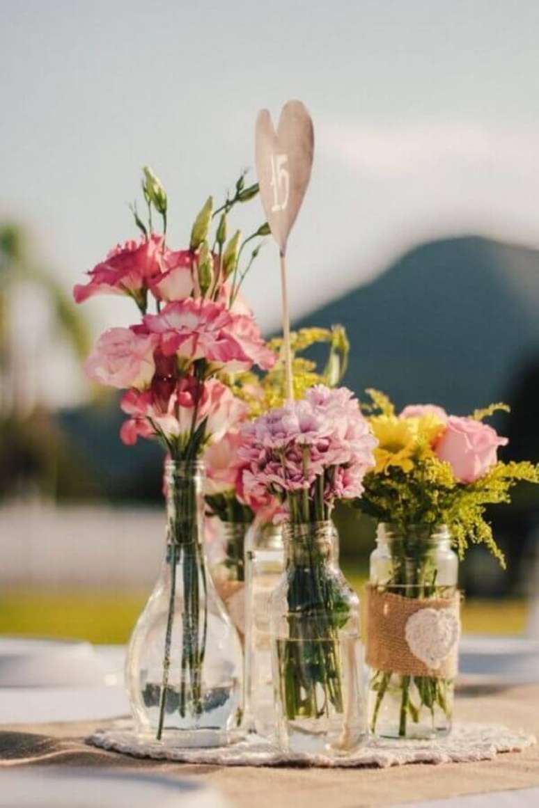 61- As flores do campo foram colocadas em v&aacute;rios recipientes de vidro transparente para decorar o evento. Fonte: Transforme Sua Casa