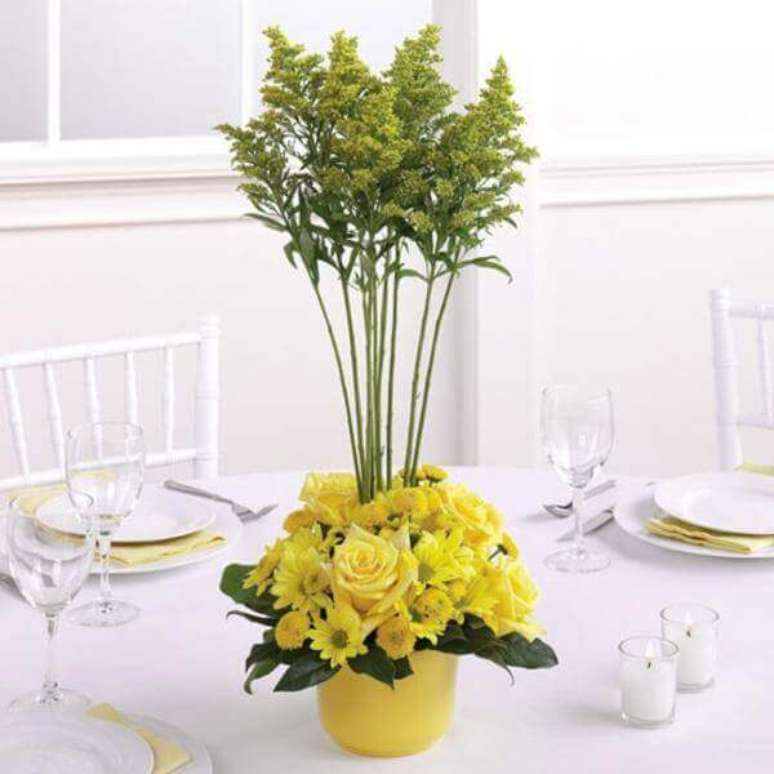 48- As mesas do evento foram decoradas com toalhas, louças, cadeiras brancas, guardanapos e vaso de flores do campo amarelas. Fonte: Em Breve Casados