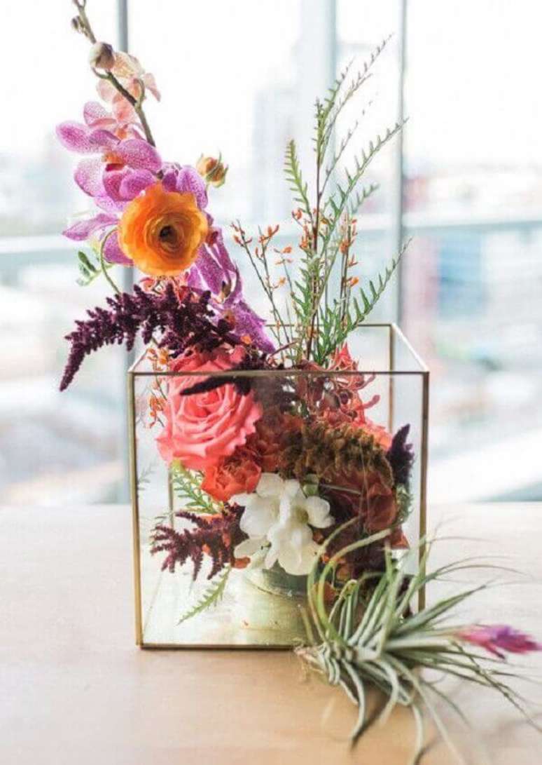 50- O arranjo decorativo com flores do campo foi montado em cachepot de vidro com filete dourado. Fonte: Pinterest