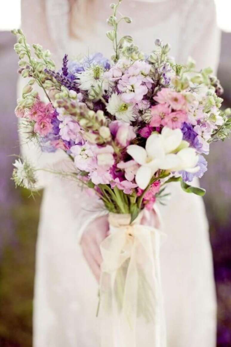 51- O buquê da noiva com flores do campo foi montada nas cores lilás, rosa e branca. Fonte: Presentes por Ocasião