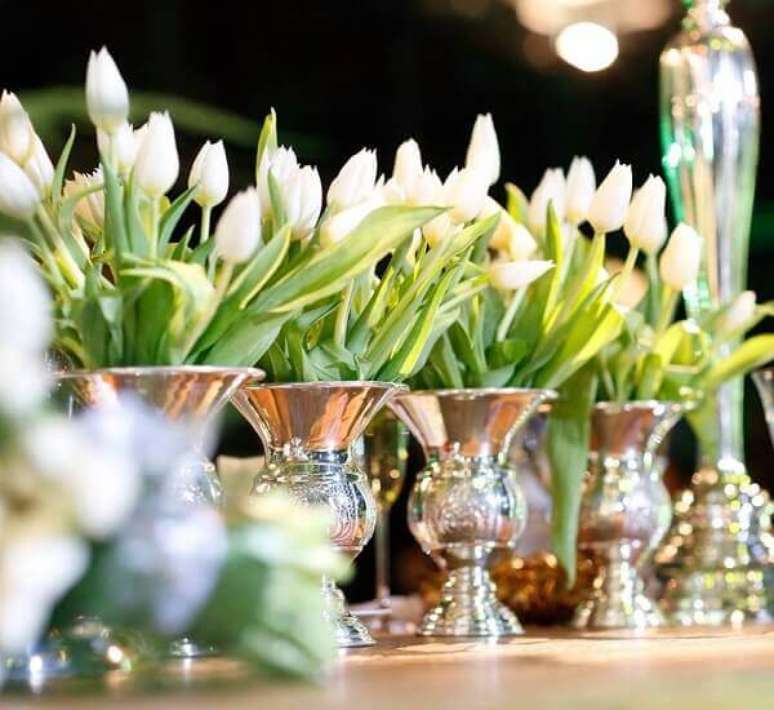 55- As flores do campo como a Tulipa branca foram colocadas em vasos de prata sobre a mesa. Fonte: Beto Burim Decorações