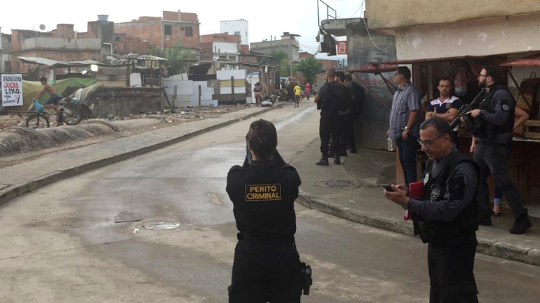 Peritos na rua São Daniel fotografando a torre branca ao fundo da comunidade