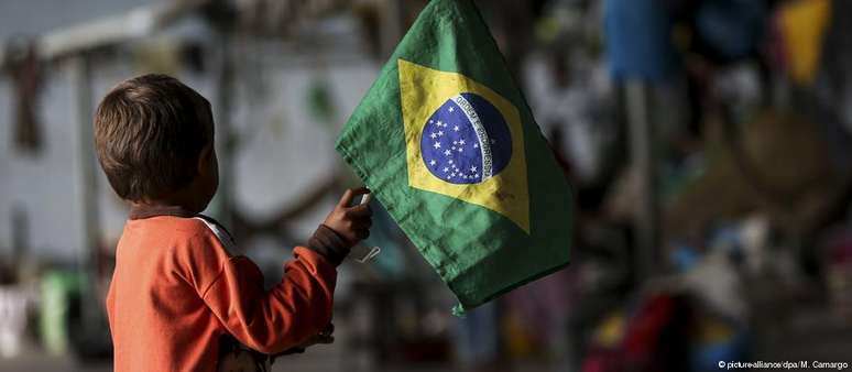 Criança venezuelana segura bandeira brasileira em Roraima: porta de entrada para refugiados