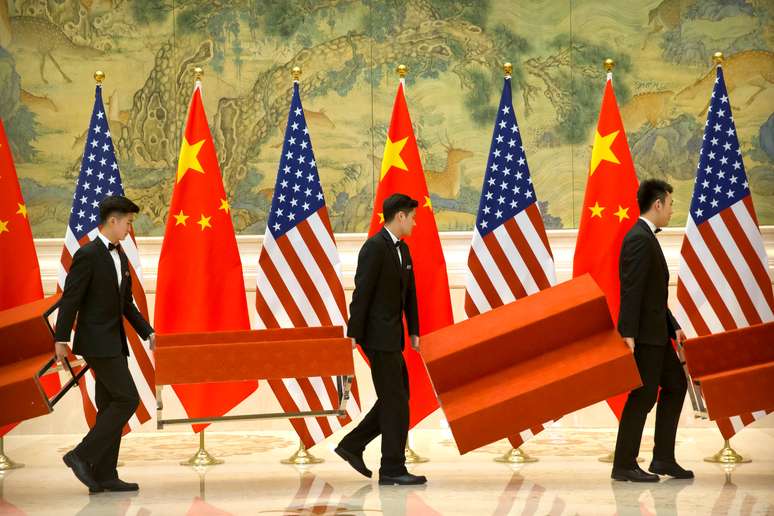 Assessores preparam cenário para fotos de líderes dos Estados Unidos e da China que negociam um acordo comercial. 15/2/2019. Mark Schiefelbein