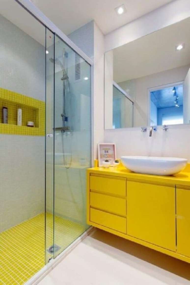 20- O banheiro pequeno decorado tem pastilhas amarelas no piso e no nicho interno do box. Fonte: Casa e Construção