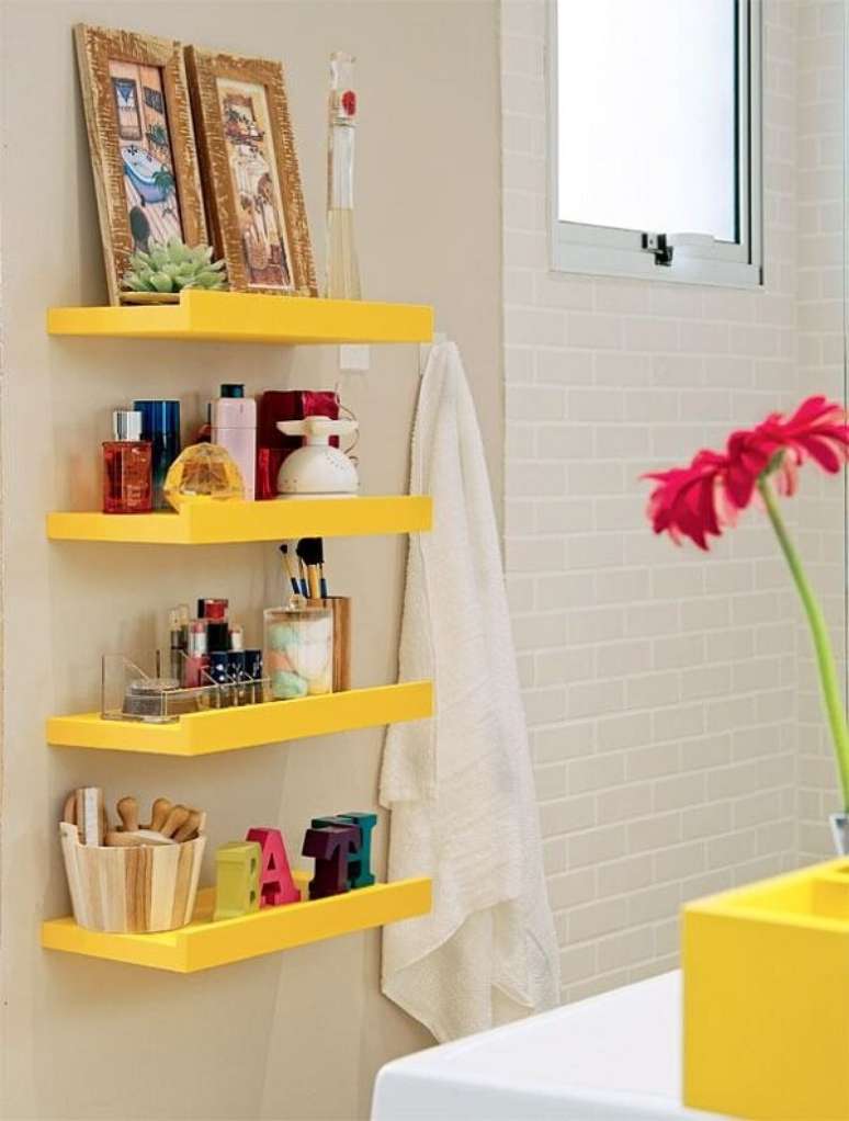 28- O banheiro decorado pequeno tem quatro prateleiras amarelas que combinam com a cuba. Fonte: Canal da Decoração