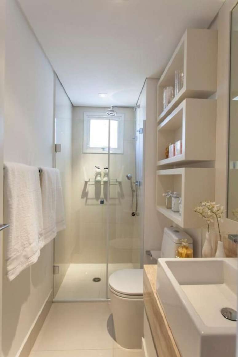 29- O banheiro pequeno decorado com linhas modernas tem três nichos grandes sobre a caixa acoplada. Fonte: Pinterest