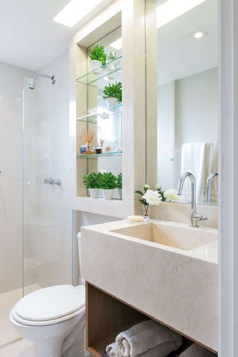 70- O banheiro pequeno decorado tem bancada e nicho feitos do mesmo material e prateleiras de vidro transparente. Fonte: Pinterest