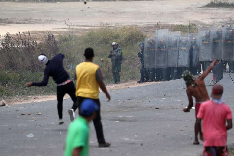 Manifestantes atiram pedras em direção às forças militares venezuelanas