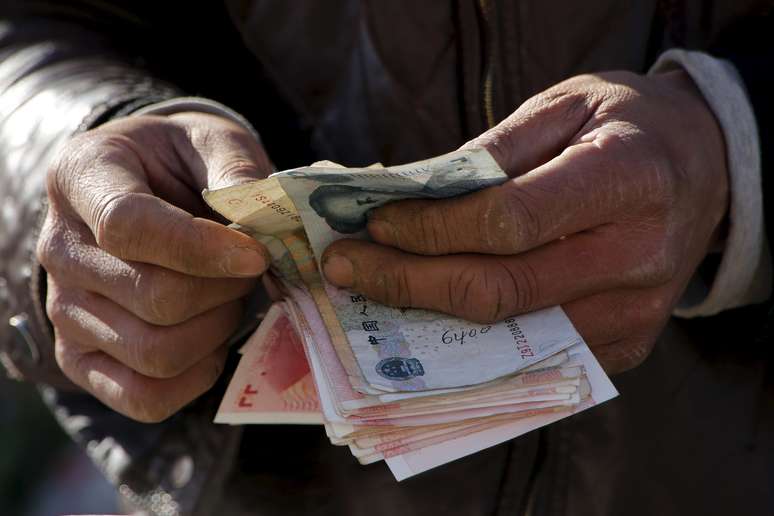 Homem conta notas de renminbi, moeda chinesa, em Pequim
10/03/2016
REUTERS/Kim Kyung-Hoon