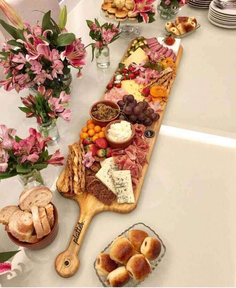 52. Decora&ccedil;&atilde;o de mesa de frios para casamento com arranjos de flores e t&aacute;bua de madeira &ndash; Foto: Zozu