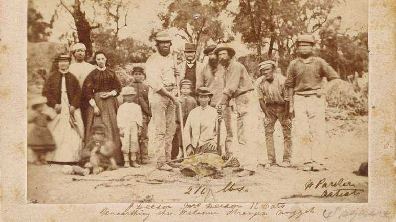 Fam&iacute;lias locais posaram ao lado dos mineradores que descobriram a pepita - que j&aacute; tinha sido fragmentada antes desta foto