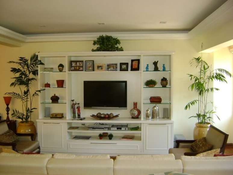 51 – O par de vasos bege com plantas para sala foram posicionados ao lado da estante da TV. Fonte: Meu Estilo